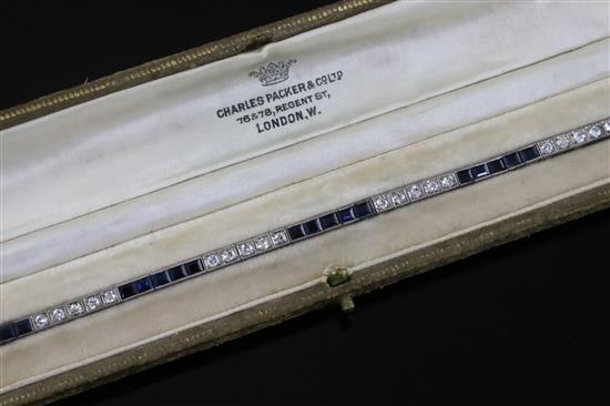 A 1920s 18ct white gold, sapphire and diamond set line bracelet, in original fitted Charles Packer & Co Ltd box.